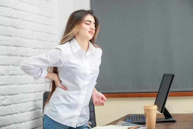 imagem de jovem com dor nas costas depois de ficar muito tempo sentada