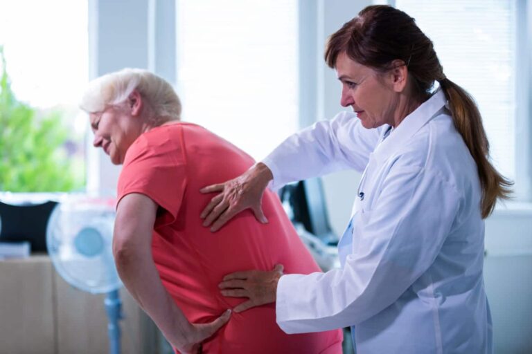 imagem de médica fazendo diagnóstico nas costas de uma paciente idosa com dor nas costas
